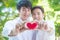Homosexual couple holding red color heart shape and smile together