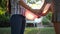 Homosexual couple with inflatable balloons and bracelet LGBT hold hands in backlight