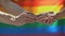 Homosexual male putting wedding ring on partner, lgbt flag background, equality