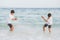 Homosexual portrait young asian couple play water on beach with cheerful together in summer