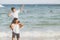 Homosexual portrait young asian couple riding the neck together with enjoy and fun on beach in summer