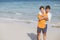 Homosexual portrait young asian couple standing hug together on beach in summer