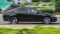 Honda Accord rides on a street. Black 5-door sedan motor car rushes on the road with blurred background