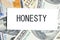 HONESTY text, a word written on a white business card against a background of money