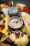 Honey in bowl with spoon , various cheese and berries