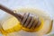 Honey dipper on the bee honeycomb background. Honey tidbit in glass jar and honeycombs wax