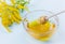 Honey drip from a wooden honey dipper in glass bowl on a blue background