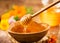 Honey dripping from honey dipper in wooden bowl.  Close-up. Healthy organic Thick honey dipping from the wooden honey spoon