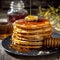 Honey dripping on the stack of pancakes for breakfast on the wooden table