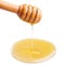 Honey dripping from a wooden dipper on isolate white background.
