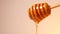 Honey drizzling and dripping from a honey dipper. Copy space on left.