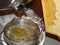 Honey flowing out of a centrifuge into a sieve, honeycomb in the