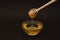 Honey in Glass bowl with dipper over dark Background Isolated with copy space.