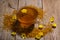 Honey in the glass bowl, pollen and yellow flowers around it