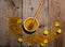 Honey in the glass bowl, pollen and yellow flowers around it