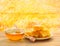 Honey in glass bowl, wooden honey dipper and honeycombs with honey on wooden table on background honeycombs with full cells