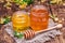 Honey in glass, honey stick and blooming linden on an old board