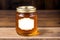 Honey in a glass jar on a wooden background. Selective focus. healthy food concept. Generative AI