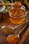 Honey in a glass jar with a wooden spoon. Still life on a wooden table with yellow flowers Goldenrod. Healthy sweet food