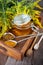 Honey in a glass jar with a wooden spoon. Still life on a wooden table with yellow flowers Goldenrod. Healthy sweet food. Close up