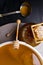 Honey in jar and big bucket, honeycomb and wooden stick, metal ladle