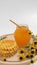 Honey jar. Dips wooden stick to glass bowl with liquid floral fresh honey