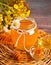 Honey in jar and honeycomb in small bowls.