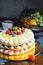 Honey layer cake with whipped cream, strawberries and blueberries on the table.