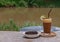 Honey lemon coffee with Chocolate Brownie Cake on wooden background with river view