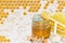 Honey and pieces of garlic on the background of honeycomb. Honey in a glass jar and honeycomb