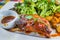 Honey Pork Ribs Served with Salad and Spicy Sauce in White Plate on Colourful Table