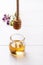 Honey in a small glass jar on a white table Honey dripping from dipper