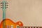 Honey sunburst electric guitar and neck on rough cardboard background, with plenty of copy space.