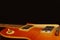 Honey sunburst vintage electric blues guitar closeup on the black background, with plenty of copy space.