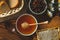 Honey in white ceramic bowl, honey dripper spoon, homemade honeycomb on rustic wooden table