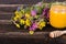 Honey, wild flowers and spoon on wooden background. Free space for your text.