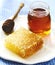 Honeycombs with honey, honey in glass jar and wooden honey dipper