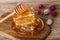 Honeycombs and honey spoon on a wooden board and table