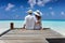 Honeymoon couple hugging on a wooden jetty in the Maldives islands