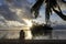 Honeymoon couple looks at the sunrise from a tropical pacific is