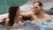 Honeymoon couple relaxing together in hot tub whirlpool jacuzzi luxury resort