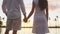 Honeymoon couple romantic at sunset holding hands in love enjoying vacation