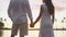 Honeymoon couple romantic at sunset holding hands in love enjoying vacation