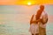 Honeymoon sunset couple hugging on beach vacation travel luxury tropical destination for newlyweds