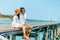 Honeymoon travel couple romantic  hugging and sitting on wood bridge and enjoys their tropical holiday