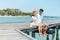 Honeymoon travel couple romantic  hugging and sitting on wood bridge and enjoys their tropical holiday