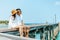 Honeymoon travel couple romantic  hugging and sitting on wood bridge and enjoys their tropical holiday