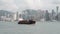 Hong Kong, China - August 15, 2018 : Small cargo ship crossing the victoria habour and city skyline