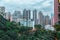 Hong Kong city private residential high-rise buildings in the evening. Scenic cloudy cityscape with green trees and skyscrapers