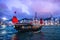 HONG KONG - JUNE 09, 2015: A Chinese traditional junk boa sailing passing famous Hong Kong skyline. JUNE 09, 2015. They provides